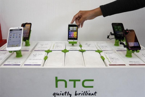 A shop attendant arranges HTC phones in a mobile phone store in Taipei