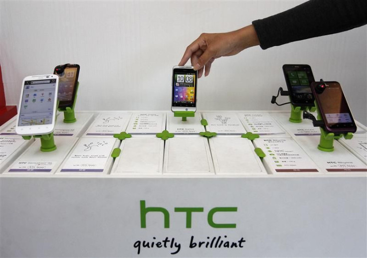 A shop attendant arranges HTC phones in a mobile phone store in Taipei