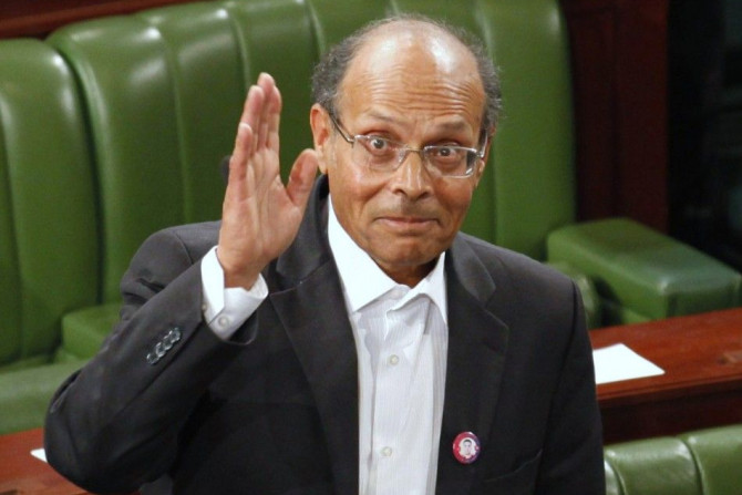 Former doctor and human rights campaigner Moncef Marzouki waves to the media at the constituent assembly in Tunis