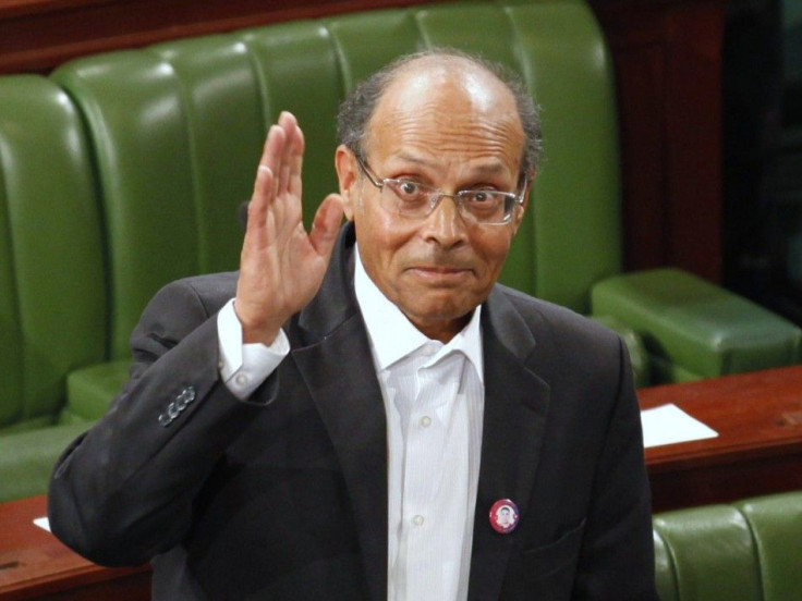 Former doctor and human rights campaigner Moncef Marzouki waves to the media at the constituent assembly in Tunis