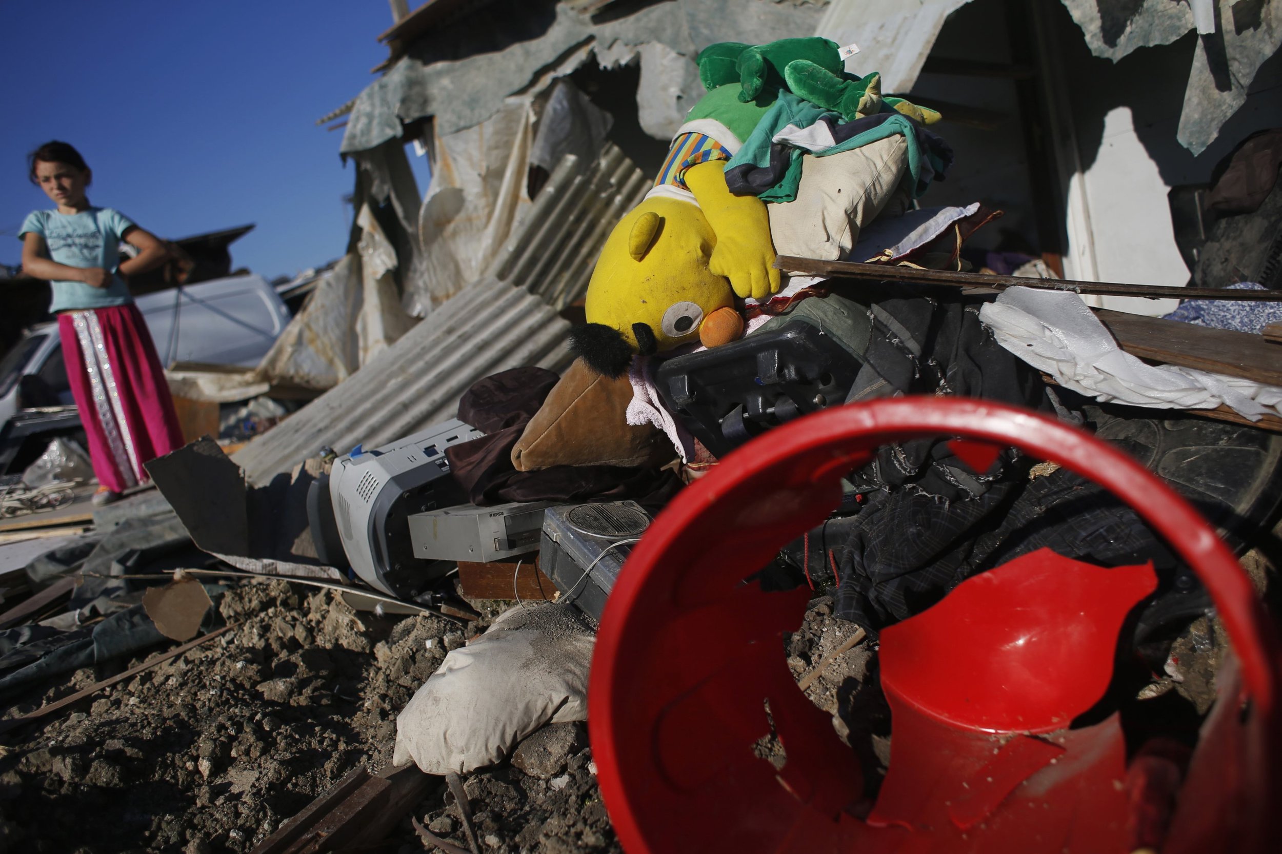 A girl stands next to the remains of home demolished by Spanish police during an operation in Madrids El Gallinero slum.