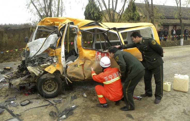 Rescuers inspect a school bus after it collided with a truck at a traffic accident site in Yulinzi township of Zhengning county