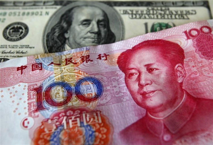 A yuan banknote is displayed next to a U.S. dollar banknote for the photographer at a money changer inside the Taoyuan International Airport, Taiwan