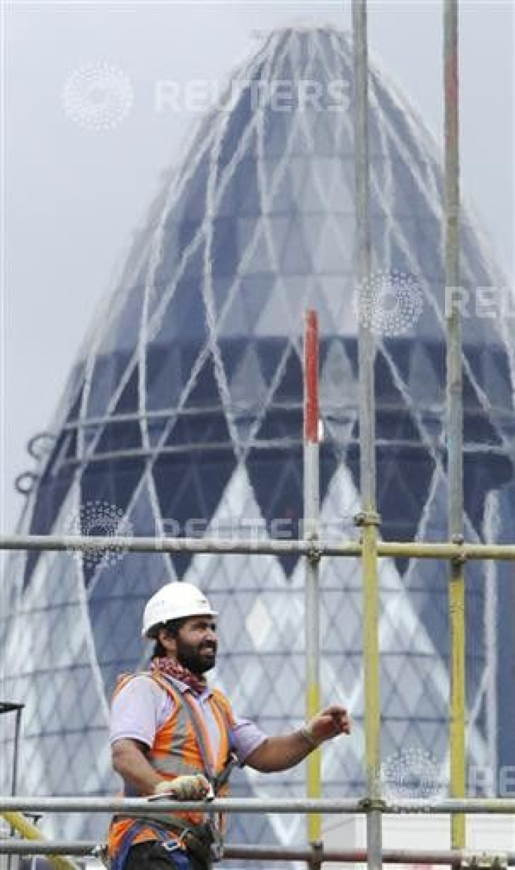 A worker takes down scaffolding on a construction site in London