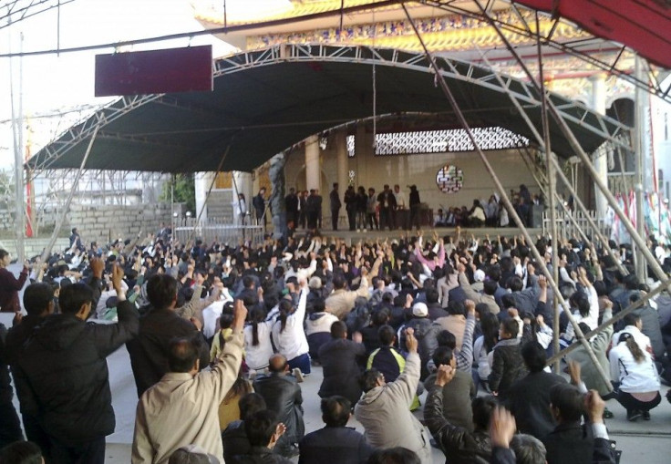 Villagers raise their hands as they gather for a meeting in Wukan village of Lufeng