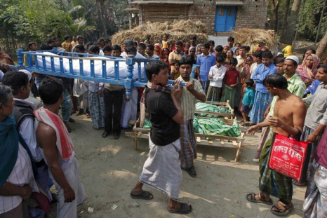 Villagers carry the body of a man, who died after consuming bootleg liquor, during his funeral near Diamond Harbour
