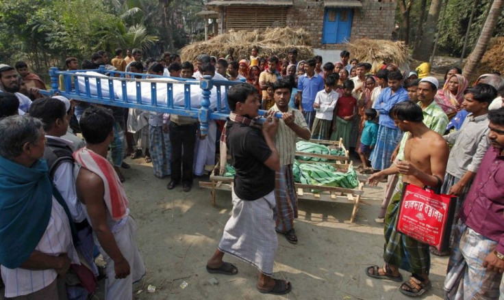 Villagers carry the body of a man, who died after consuming bootleg liquor, during his funeral near Diamond Harbour