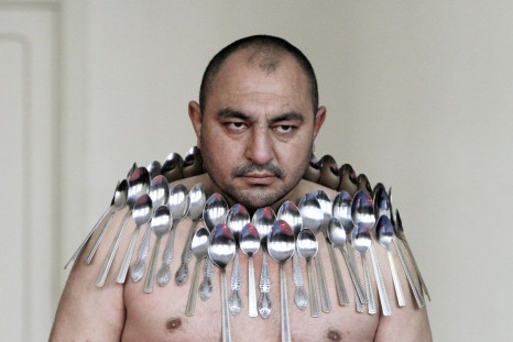 Etibar Elchyev poses with 50 metal spoons magnetized to his body during an attempt to break the Guinness World Record for