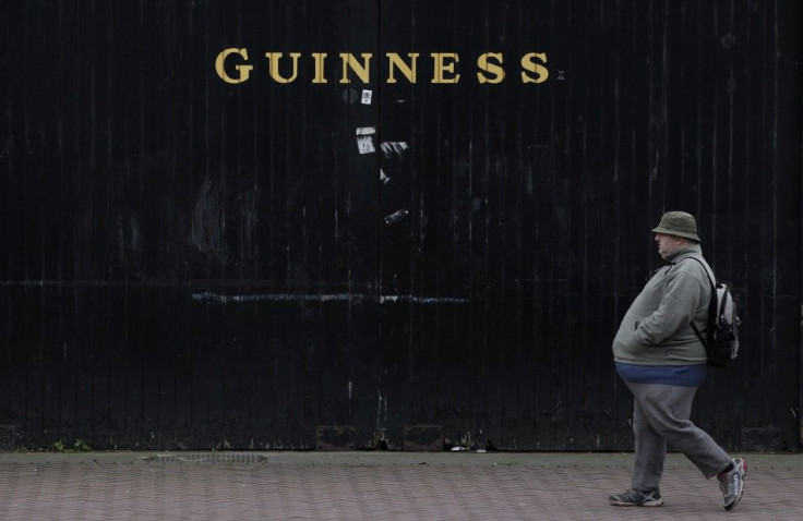 A man passes the Guinness beer factory in the city centre of Dublin