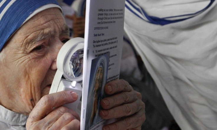A Catholic nun from the Missionaries of Charity reads a pamphlet with the help of a magnifying glass during a prayer meeting in Kolkata