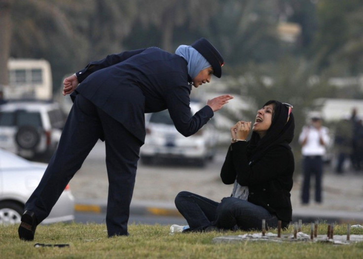A police officer speaks to Zaynab al-Khawaja, daughter of Human Rights activist, Abdulhadi al-Khawaja, after she refused to leave after a sit-in in Manama
