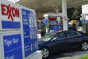 A motorist fills up her tank with gas at an Exxon gas station in Arlington