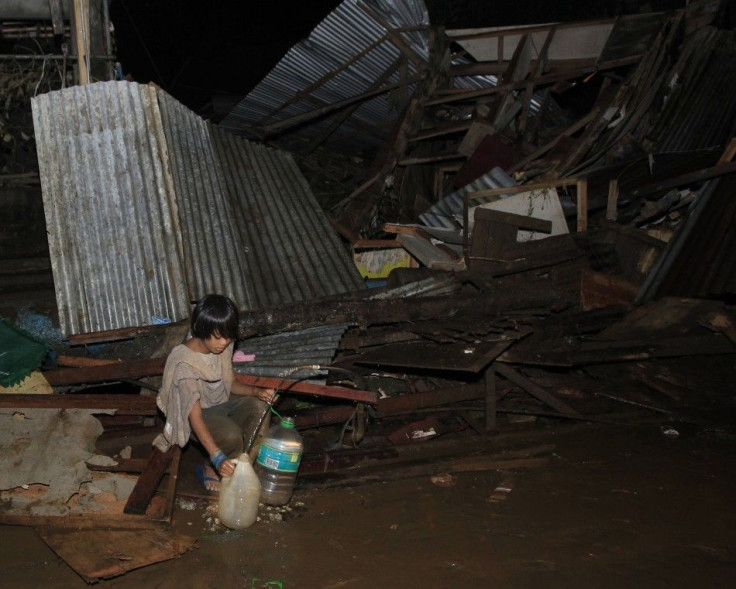 A boy fetches water from a broken pipe among destroyed houses along a road in a village hit by flashfloods caused by typhoon Washi in Cagayan de Oro, southern Philippines, December 17, 2011.