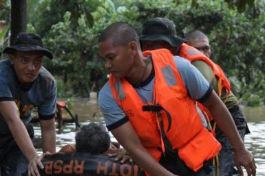 Philippine National Police rescuers use a rubber boat to evacuate a resident after flash floods brought by Typhoon Washi hit Macasandig town, Cagayan De Oro city 