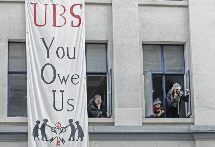 Protesters from the Occupy movement stand at the windows of one of several buildings in a quadrangle owned by banking giant UBS in the financial district City of London November 18, 2011.