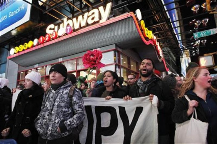 Protesters affiliated with the Occupy Wall Street movement hold a banner as they walk on the street during a protest in New York