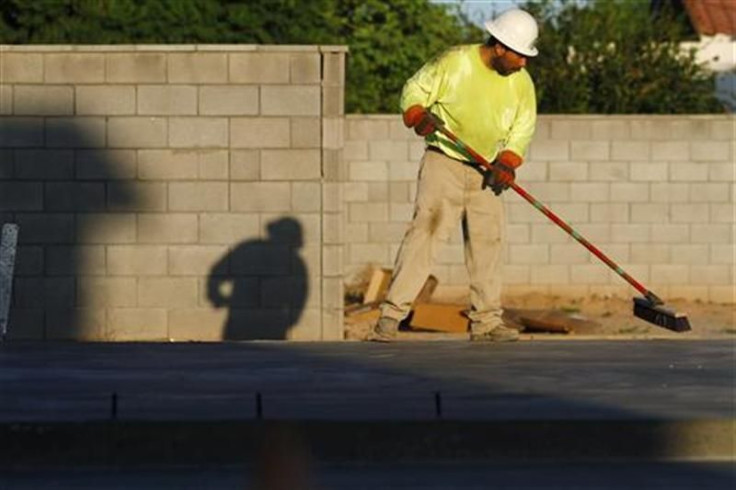 A worker sweeps the foundation of a house being constructed in Phoenix