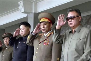 North Korean leader Kim Jong-il (R) and his son Kim Jong Un (3rd R) salute as they watch soldiers attending a military parade in the Kim Il Sung square in Pyongyang