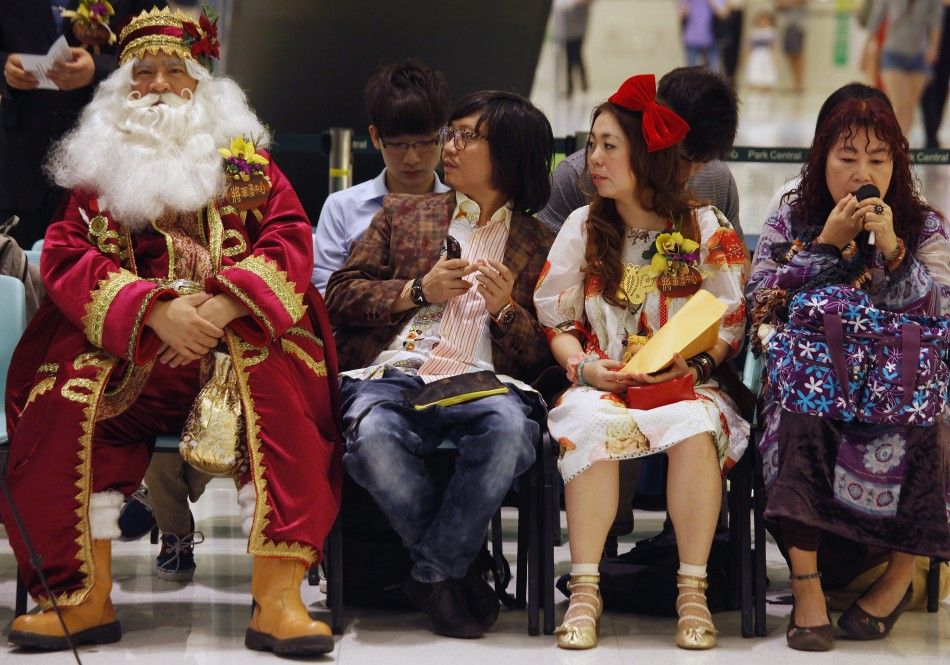 Santa Jim L, winner of the 2009 Santa Claus Winter Games, sits beside other guests during the Hong Kong round of the Santa Claus Winter Games at a shopping mall in Hong Kong November 2, 2011. Hong Kong won the championship in 2009 and came in third in 2