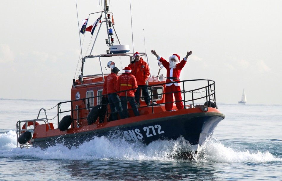 A man dressed as Santa Claus waves aboard a sea rescuers boat during the traditional Christmas bath in Villeneuve Loubet, southeastern France