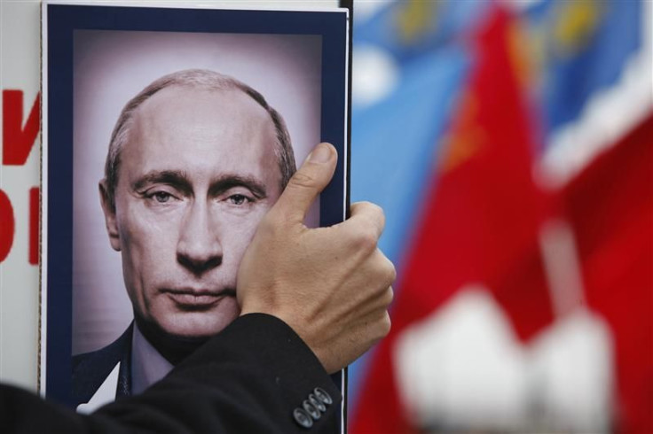 A man holds a portrait of Russia&#039;s PM Putin during a rally to protest against violations at the parliamentary elections in Stavropol