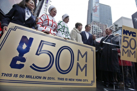 New York City Mayor Michael Bloomberg presents Craig Johnson and his wife Lucy Johnson from Lichfield England with a &quot;Golden Ticket&quot; as the city&#039;s honorary 50 millionth visitors for 2011 during a ceremony in Times Square, New York