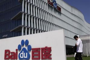 An employee walks past the Baidu company signage outside its headquarters in Beijing