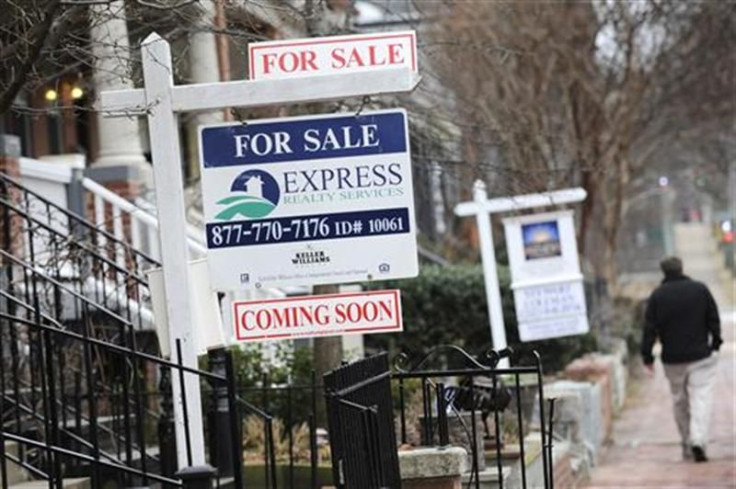 A man walks past signs marking houses for sale in Washington
