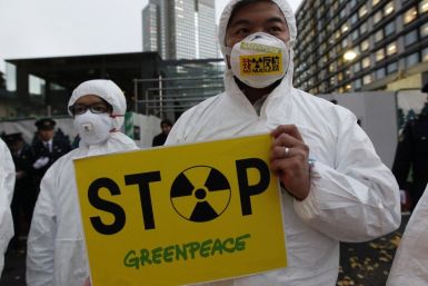 A Greenpeace activist holds a placard during a demonstration outside Japan&#039;s Prime Minister Yoshihiko Noda&#039;s official residence in Tokyo, criticizing the government&#039;s declaration of cold shutdown at the Fukushima nuclear power plant Decembe