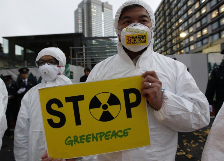 A Greenpeace activist holds a placard during a demonstration outside Japan&#039;s Prime Minister Yoshihiko Noda&#039;s official residence in Tokyo, criticizing the government&#039;s declaration of cold shutdown at the Fukushima nuclear power plant Decembe