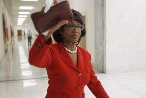 U.S. Representative Maxine Waters (D-CA) attempts to block a news camera as she walks by the members of the media near her House office on Capitol Hill in Washington in this November 16, 2010 file photo.