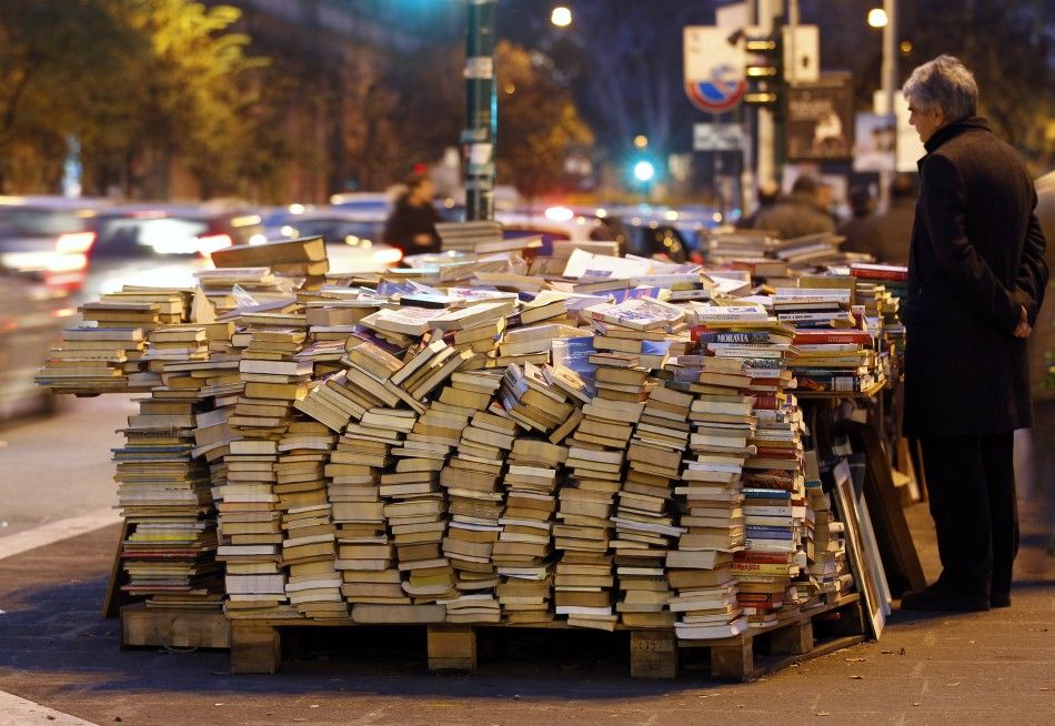 A man looks at books on display at a stall in downtown Rome
