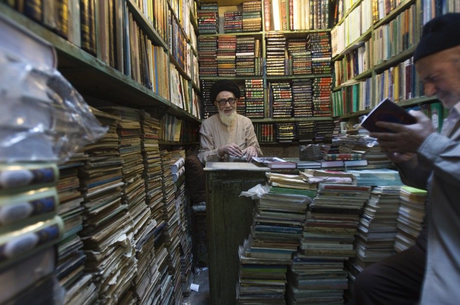A clergyman sits at his bookshop in Tabriz historic market