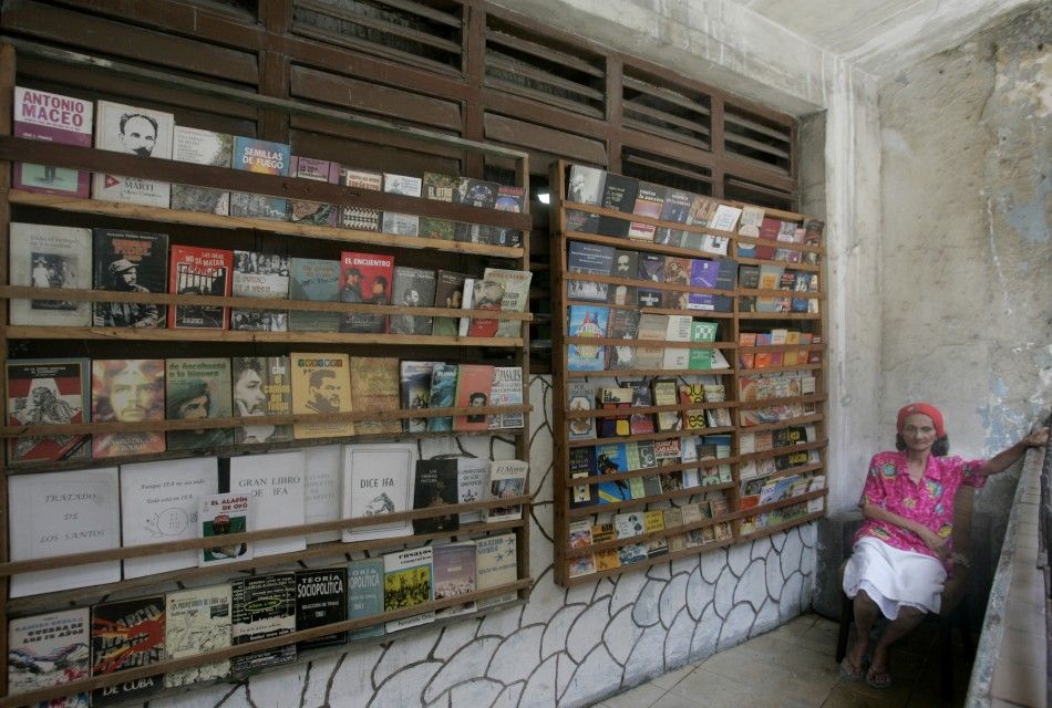 Woman offers used books for sale at a street stall in Havana