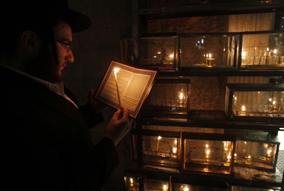 Jewish seminary student Mayer Engel recites a prayer as he lights a candle for the Hanukkah in Jerusalems Mea Shearim neighbourhood