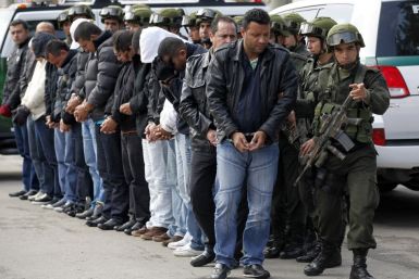 National Police escort fourteen suspected members of the &quot;ERPAC&quot; gang during their presentation to the media in Bogota