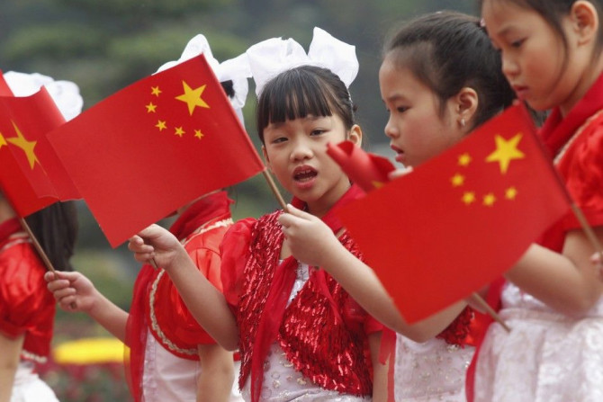 Vietnamese children wave Vietnamese and Chinese flags to welcome the visit to Vietnam by China's Vice President Xi Jinping at the Presidential Palace in Hanoi