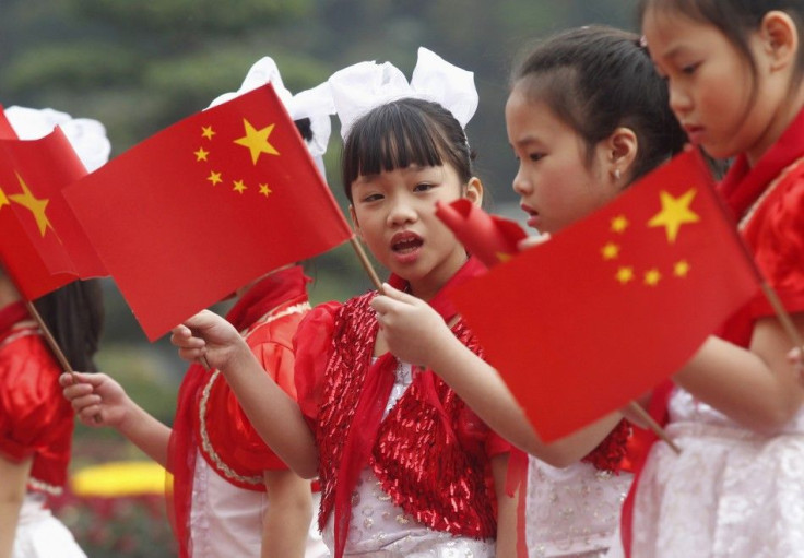 Vietnamese children wave Vietnamese and Chinese flags to welcome the visit to Vietnam by China's Vice President Xi Jinping at the Presidential Palace in Hanoi