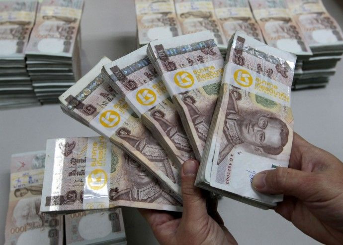 bank employee holding Thai baht
