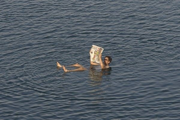 A tourist reads a newspaper as he floats in the Dead Sea resort of Ein Gedi May 20, 2010.