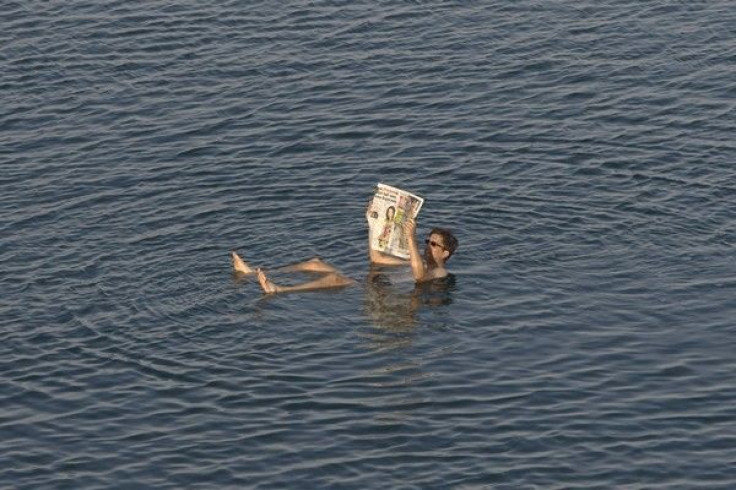 A tourist reads a newspaper as he floats in the Dead Sea resort of Ein Gedi May 20, 2010. 