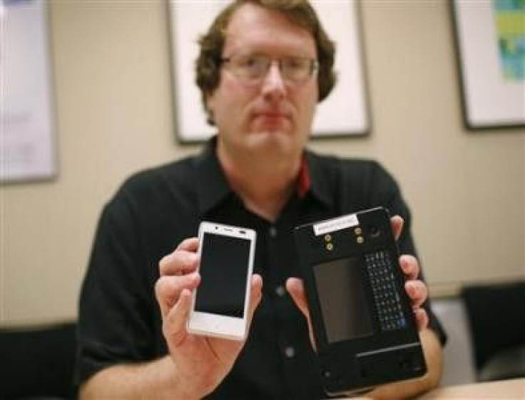 Mike Bell, co-general manager of Intel's new Mobile and Communications Group, holds an Android reference smartphone (L) he designed, next to a reference phone Intel used to demonstrate the chip at earlier stages, during an interview at the company�