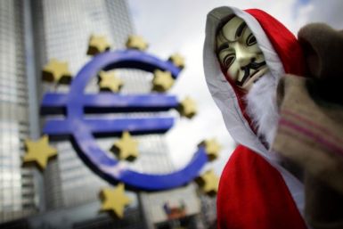 An Occupy movement protester wears a Santa Claus costume as he walks through the Occupy camp next to the euro sculpture outside the European Central Bank headquarters in the banking district of Frankfurt, Germany, on December 24, 2011.