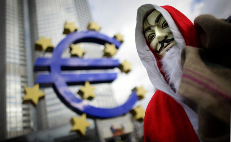 An Occupy movement protester wears a Santa Claus costume as he walks through the Occupy camp next to the euro sculpture outside the European Central Bank headquarters in the banking district of Frankfurt, Germany, on December 24, 2011.