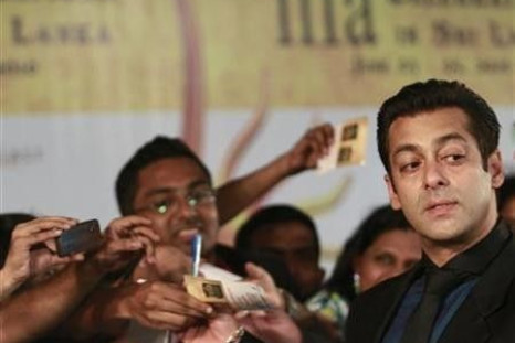 Bollywood actor Salman Khan (R) reacts on the green carpet for the International Indian Film Academy (IIFA) awards in Colombo