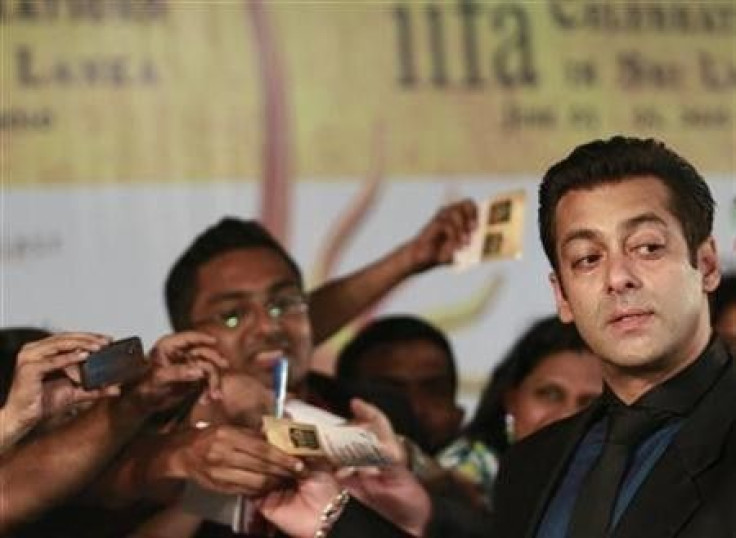 Bollywood actor Salman Khan (R) reacts on the green carpet for the International Indian Film Academy (IIFA) awards in Colombo