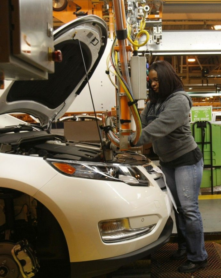 A General Motors assembly worker works on the battery installed in a 2011 Chevrolet Volt electric vehicle at the Detroit-Hamtramck Assembly plant in Hamtramck, Michigan
