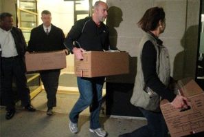 Law enforcement officials carry boxes marked &quot;Evidence&quot; out of the building housing Loch Capital Management in Boston, Massachusetts November 22, 2010