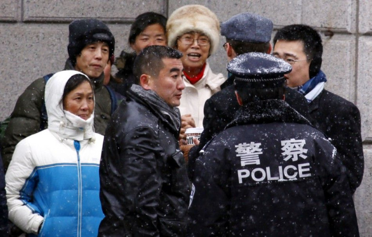 Supporters of Chinese rights activist Ni Yulan and her husband are pushed away by plain-clothes and uniformed police from the courthouse where activists are appearing on trial in Beijing