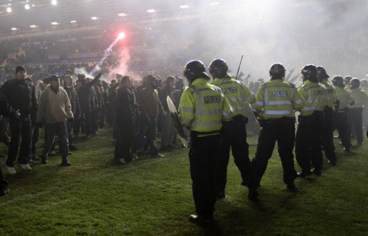 Birmingham City fans confront the police on the pitch after winning their English League Cup soccer match against Aston Villa in Birmingham.